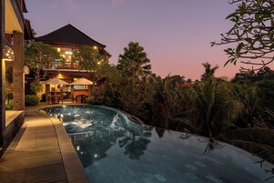 Una piscina al aire libre, sombrillas, tumbonas