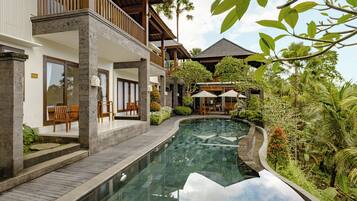 Een buitenzwembad, parasols voor strand/zwembad