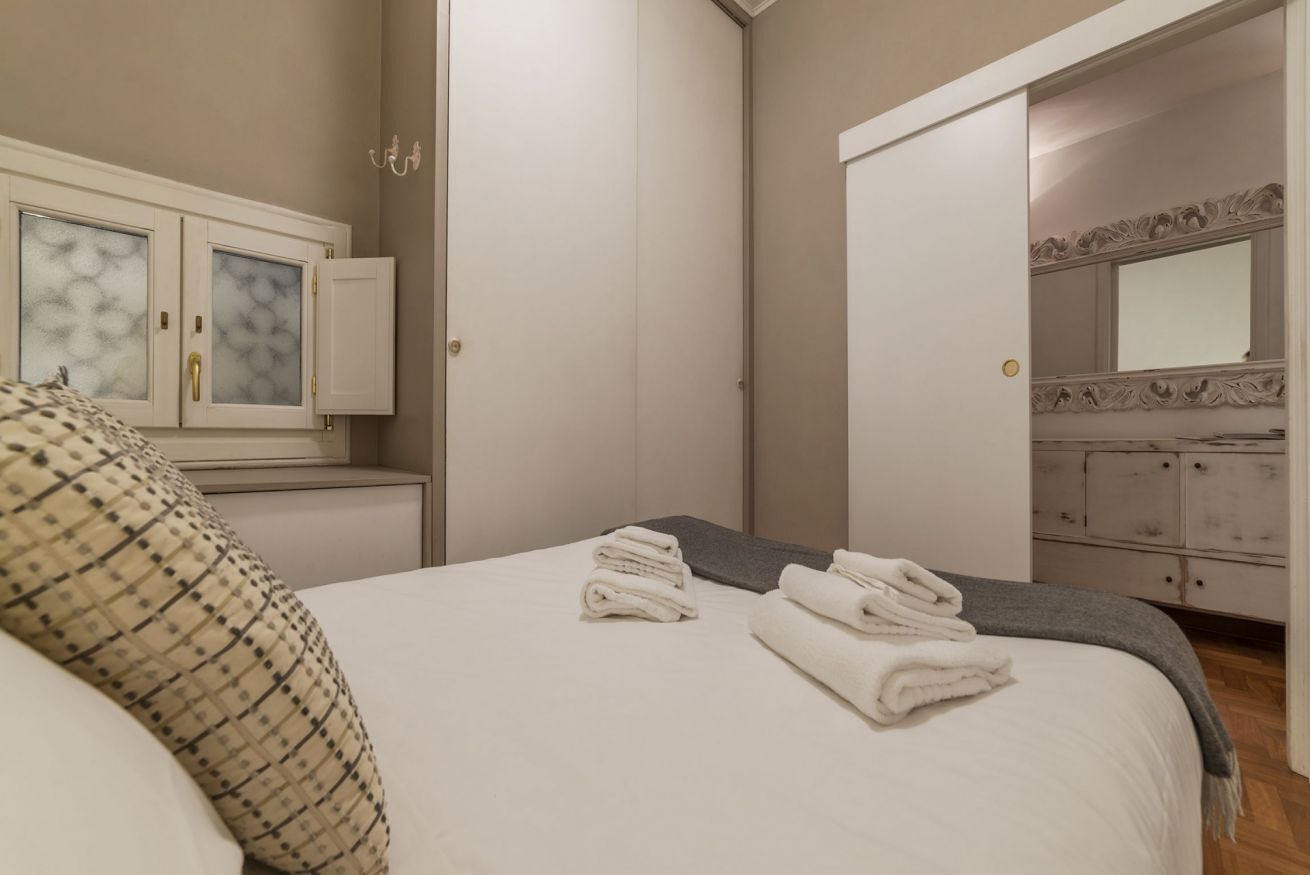 A bedroom with a bed, a dresser, and a mirror.