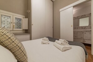 Una camera da letto con un letto, una cassettiera e uno specchio.