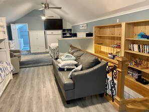 Relax in a cozy space with a leather sofa, bookshelf, and flat-screen TV.