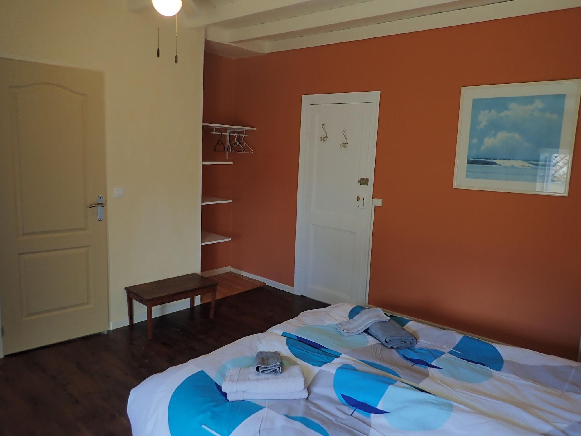 Une chambre à coucher avec un lit, une petite table, une armoire et une porte.