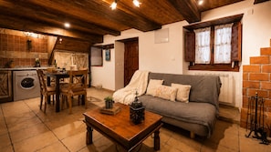A cozy living room with a sofa, a wooden coffee table, and a dining area with a table and chairs.