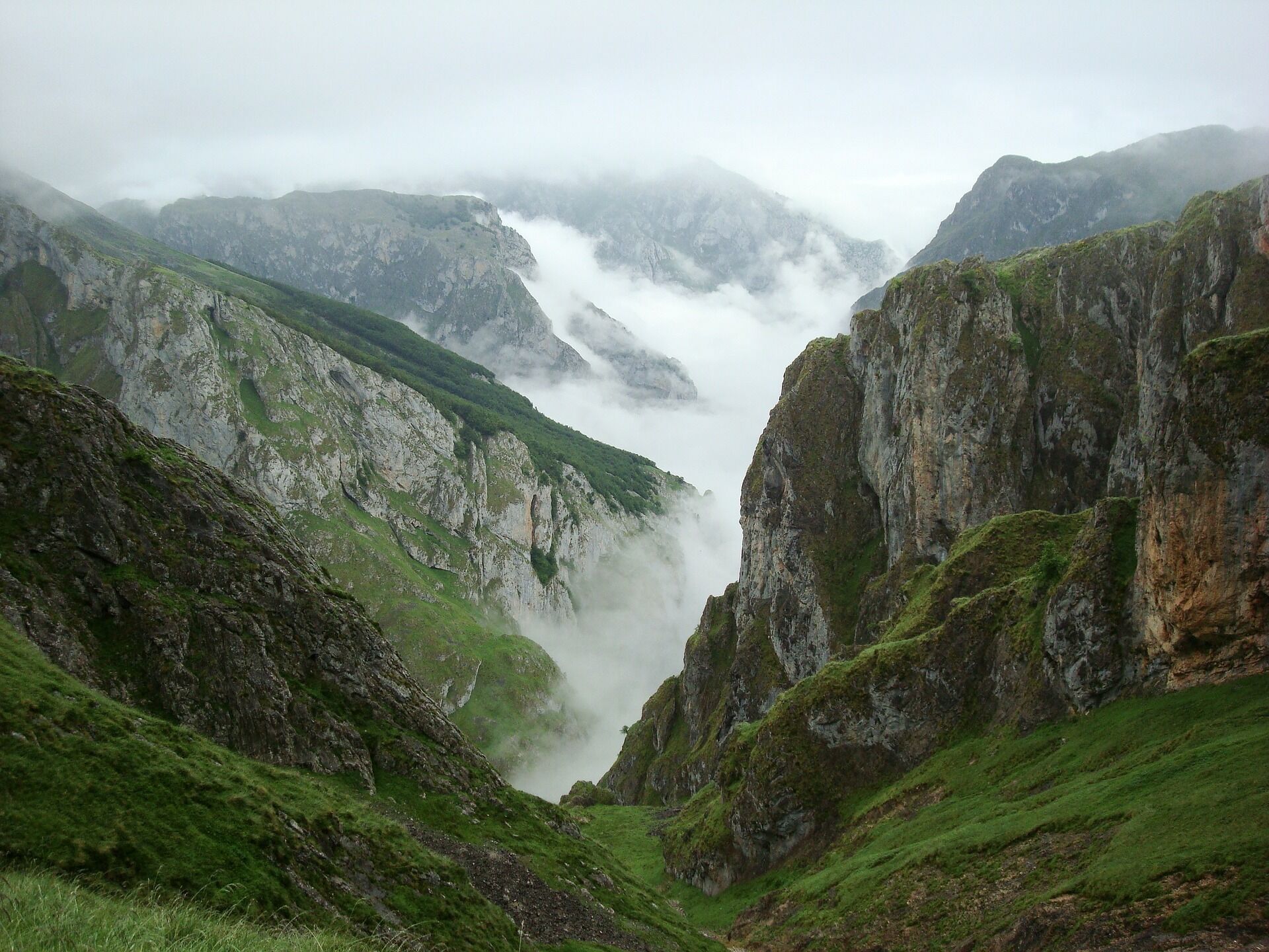 Paisagem montanhosa com penhascos íngremes e um vale.