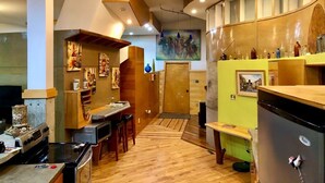 A modern kitchen with a wooden countertop, built-in oven, and a dining area with chairs. - One of a kind cabin in the woods.  Quiet and private but close to everything.  (Coxs Creek)