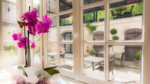 Una ventana con varios cristales, una orquídea en maceta y una mariposa.