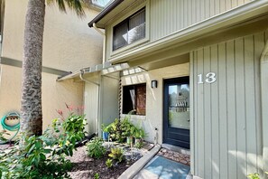 A two-story building with a number 13 sign, a covered entrance, and a variety of plants in the front yard. - Updated 2 bedroom/2.5 bath townhouse, perfect for a large family beach getaway!! (Saint Augustine)