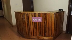 Un comptoir d’accueil avec une pancarte sur laquelle on peut lire « KARIBU ».