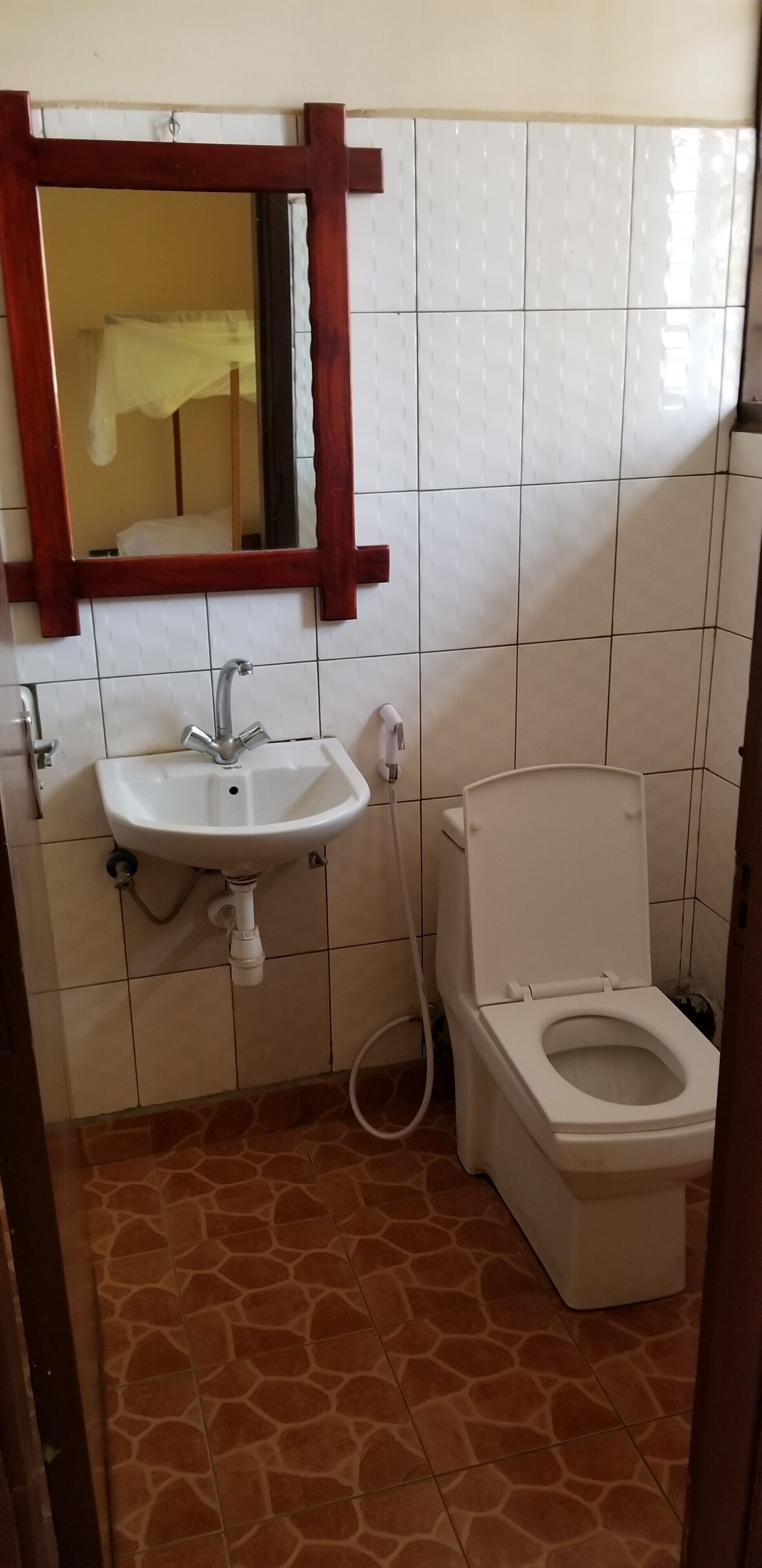A bathroom with a white sink, a mirror, and a toilet.