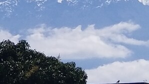 Une montagne enneigée, avec un ciel dégagé et quelques nuages.