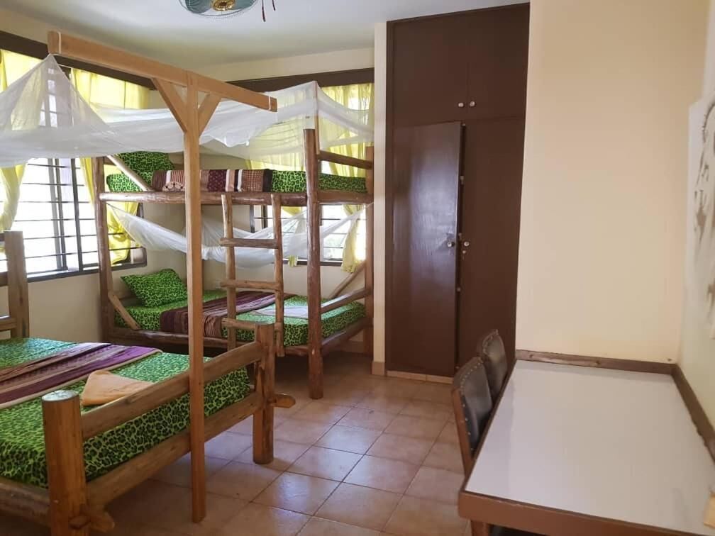 Una habitación con literas, una mesa de comedor y una puerta.