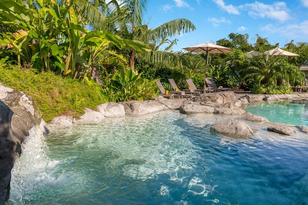 Een buitenzwembad, parasols voor strand/zwembad