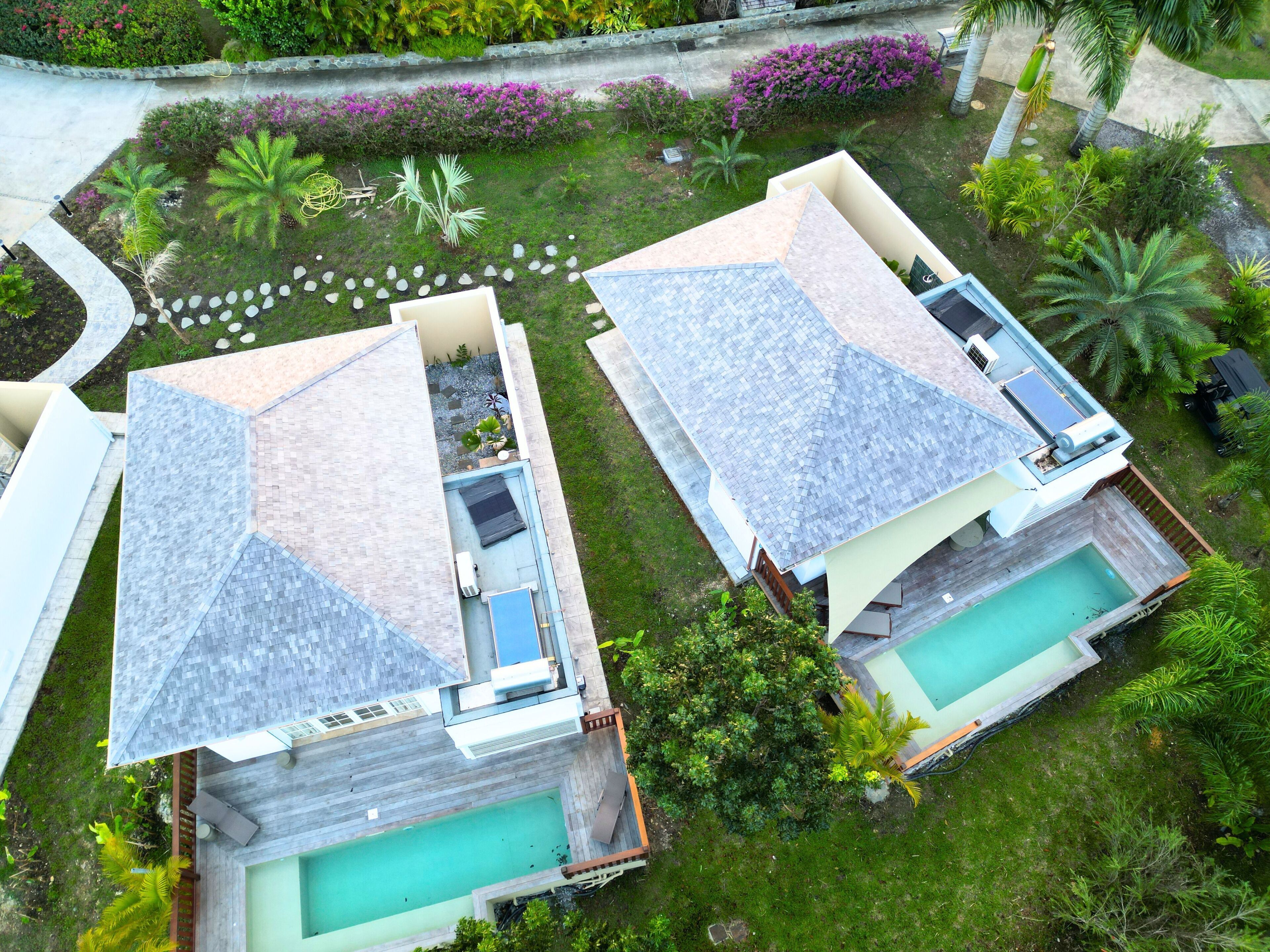 Two modern houses with sloped roofs, each with a swimming pool and a small deck area.