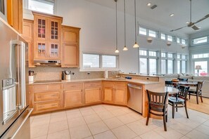A spacious kitchen with wooden cabinets, a large island, and a dining area with chairs.