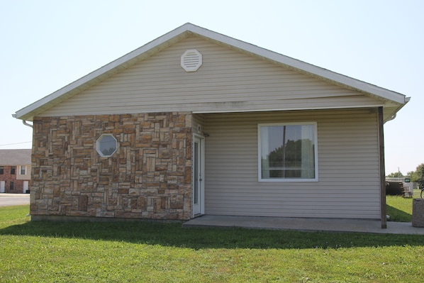 A small single-story building with a stone facade and a beige exterior. - Pet Friendly Lodging Close to Whiteman AFB and Warrensburg (Warrensburg)