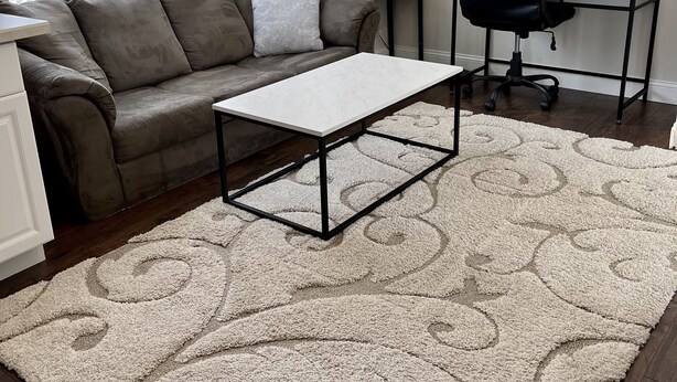 Una sala de estar con sofá, mesa de centro, escritorio y una silla.