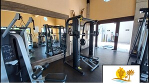A gym with various exercise equipment, including a squat rack and weight machines. - CCV Quivira-Lux 2BR, Lg Patio w/Outdoor Kitchen, Ocean View, Golf! (Cabo San Lucas)