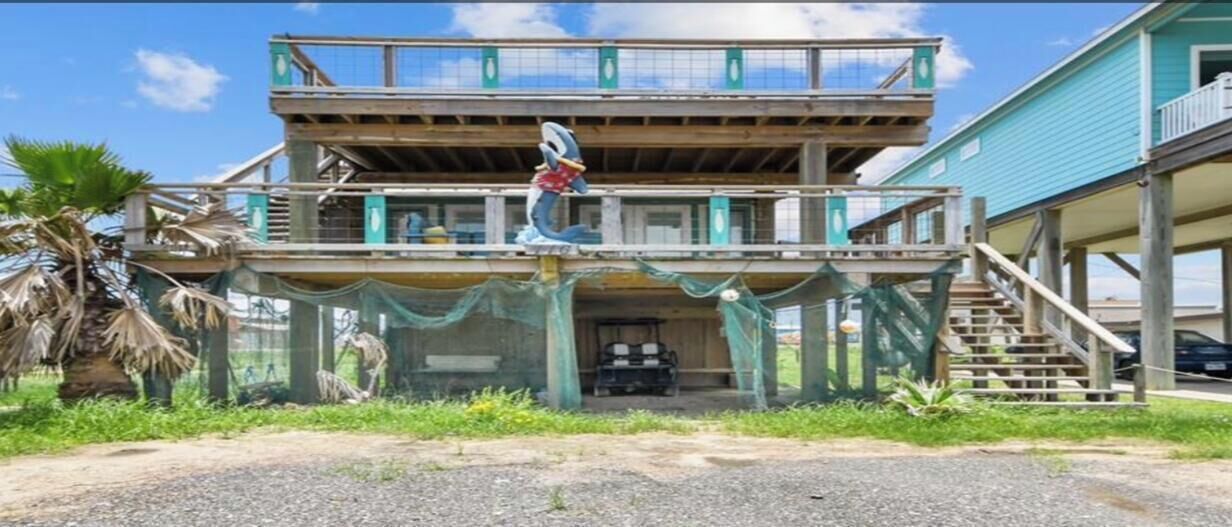 A two-story building with a balcony, a staircase, and a small porch area.