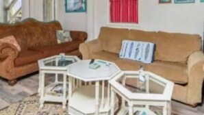 A living room with two sofas, a coffee table, and a small white table.