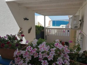 Enjoy the serene sea views from this balcony, surrounded by lush potted plants.