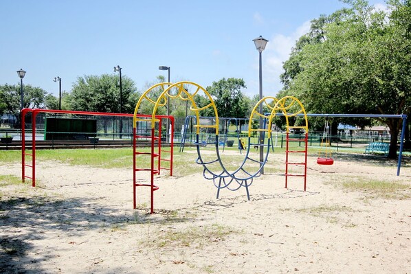 A playground with swings, a slide, and climbing structures. - Beach House with a lake. (Surfside Beach)