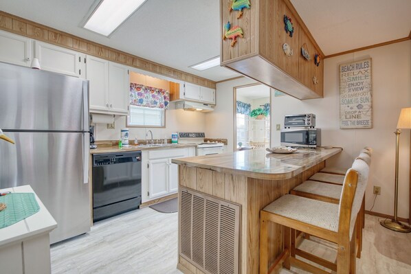 Enjoy cooking in this kitchen with a central island, bar stools, refrigerator, dishwasher, and microwave.