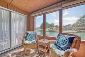 Relax in a serene outdoor space with a view of the lake and neighborhood, featuring two comfortable chairs and a small table.