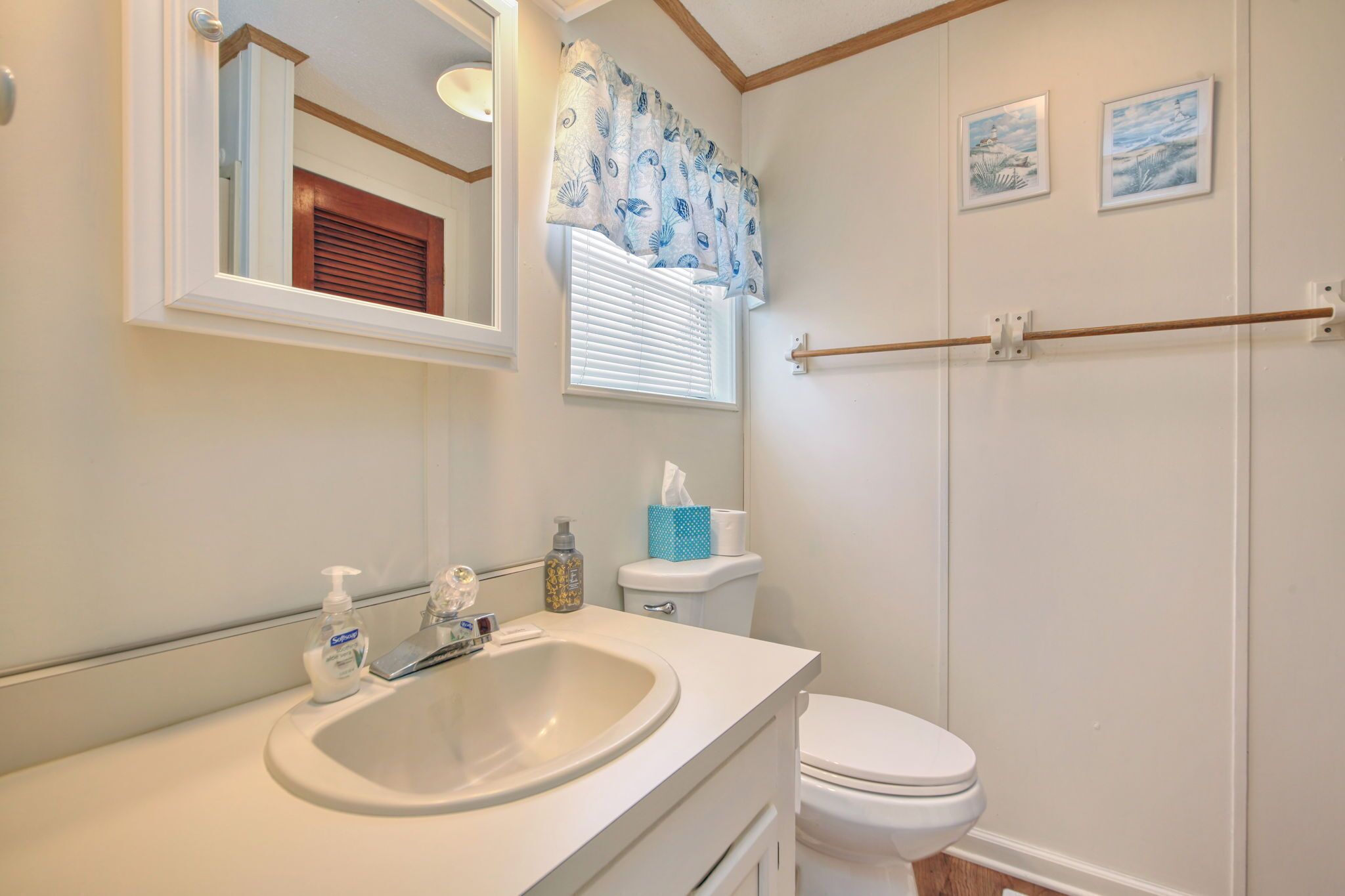Une salle de bain avec un lavabo, des toilettes et un miroir.