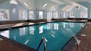 An indoor swimming pool with clear blue water, surrounded by windows and a tiled floor. - Beach House with a lake.  (Surfside Beach)