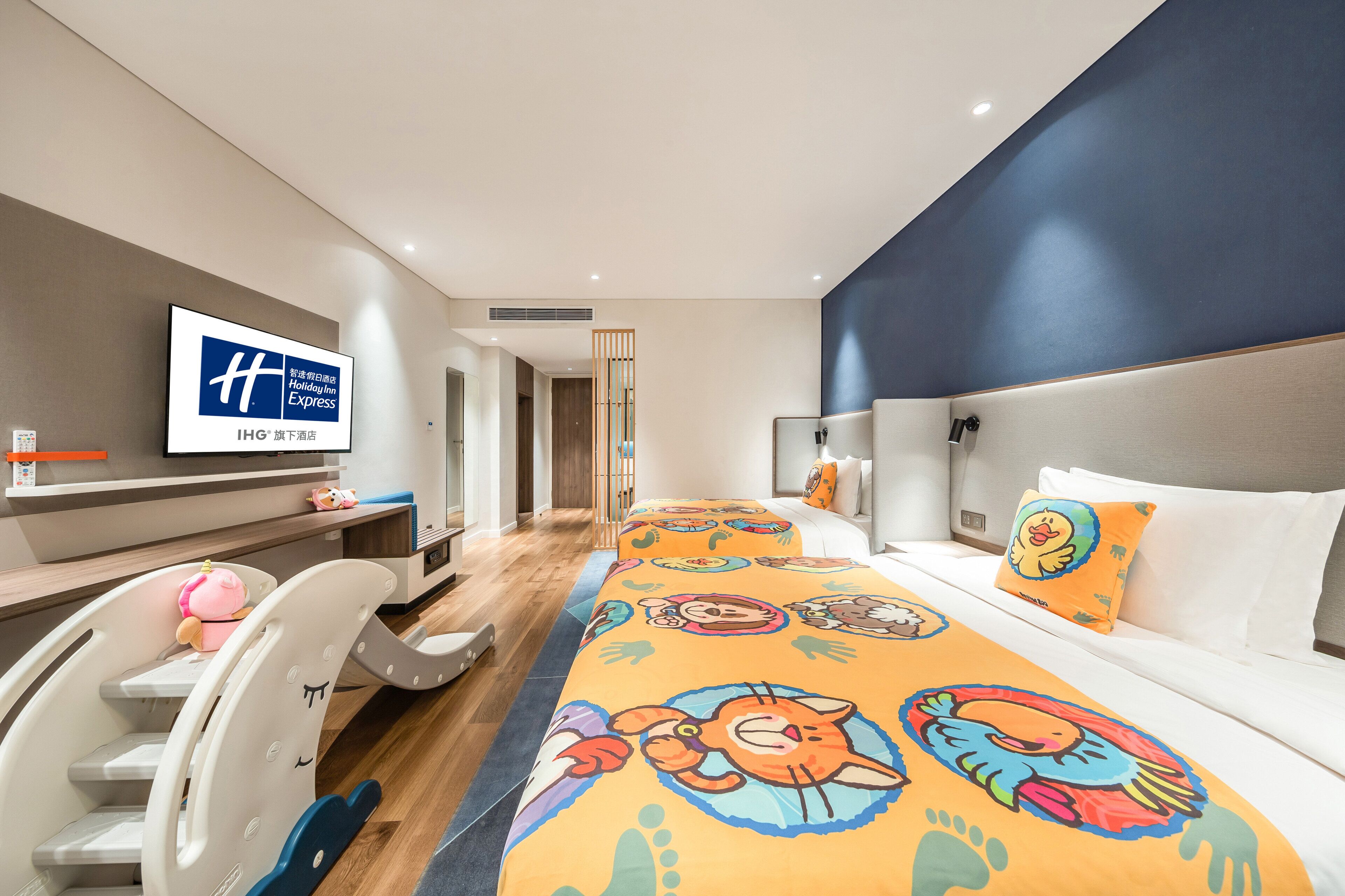 Una habitación de hotel con una cama grande, televisión, escritorio y una silla.