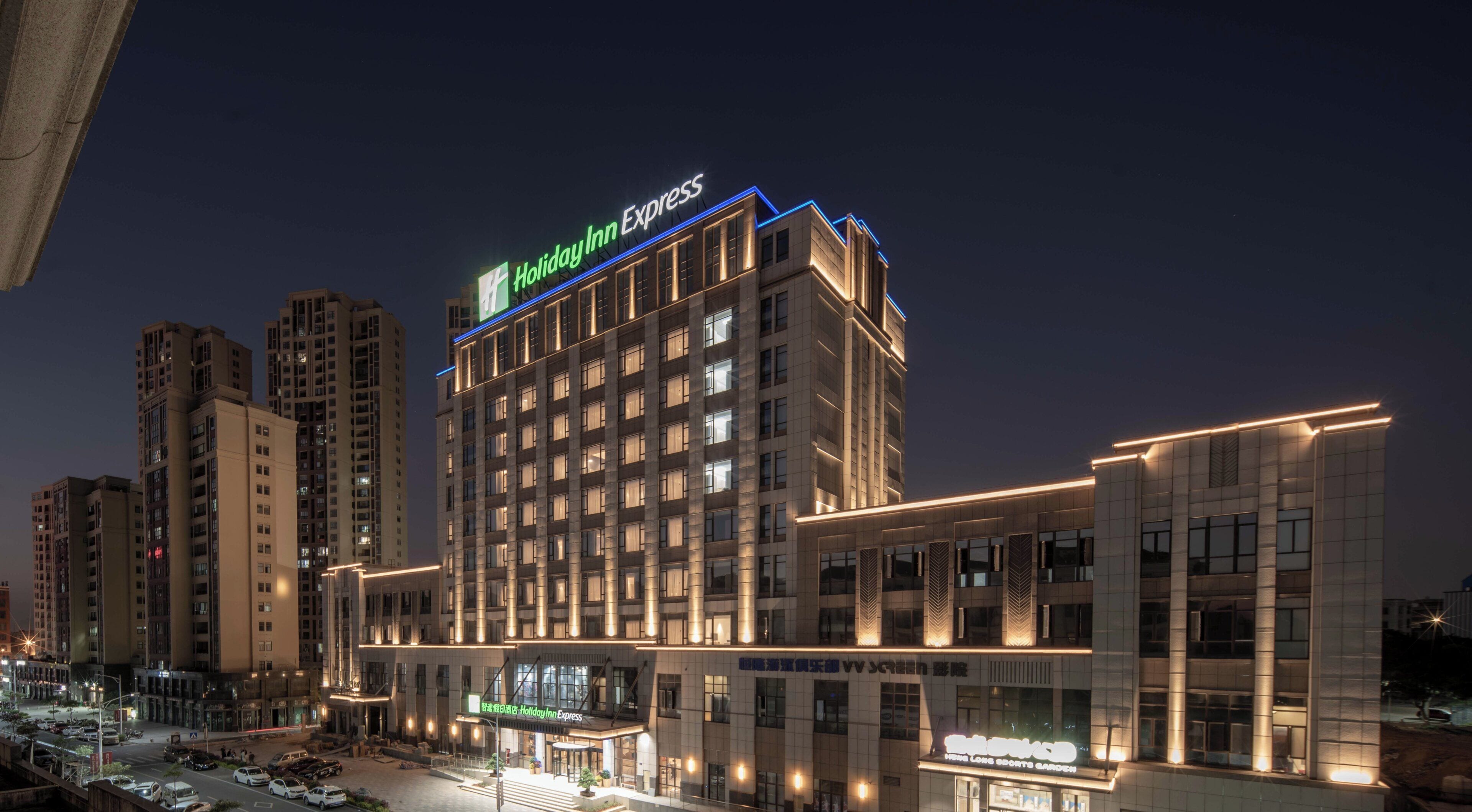 A multi-story hotel with a prominent 'Holiday Inn Express' sign, a ground-level restaurant, and a parking lot.