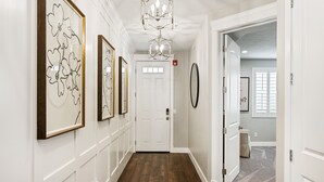 A hallway with wooden flooring, white walls, and framed artwork. - Le Château at Las Palmas Resort - The nicest unit in the community!! (St. George)