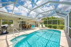 Una piscina coperta con tetto in vetro, area relax all'aperto e vista sul verde circostante.