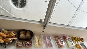 Un buffet de petit-déjeuner proposant un assortiment de pains, de viennoiseries et de fruits.