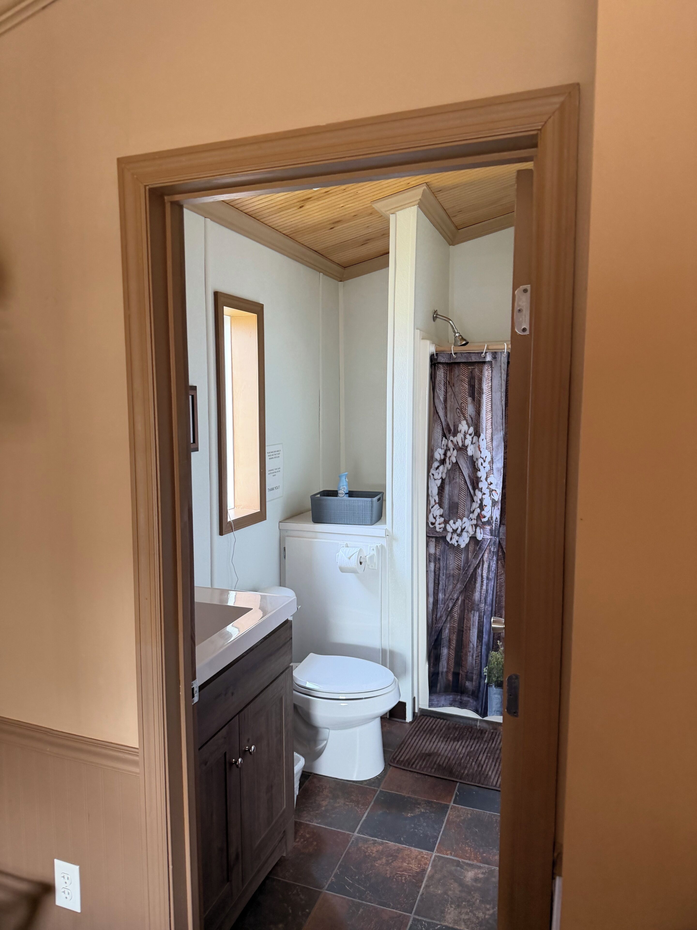 Un baño con inodoro, lavamanos y cortina de ducha.
