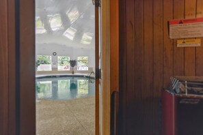 A wooden interior with a pool, windows, and a caution sign. - Soundfront Stay Beach, Pools & More at The Spa (Hilton Head Island)