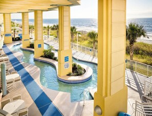 Relax by the ocean with a refreshing swim in the resort's pool, surrounded by lounge chairs and tables.