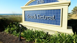 Une enseigne indiquant « Beach Retreat », avec une vue sur la plage en arrière-plan.