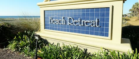 A sign for 'Beach Retreat' with a beach view in the background.