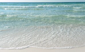 Une plage à l’eau claire et aux vagues douces.