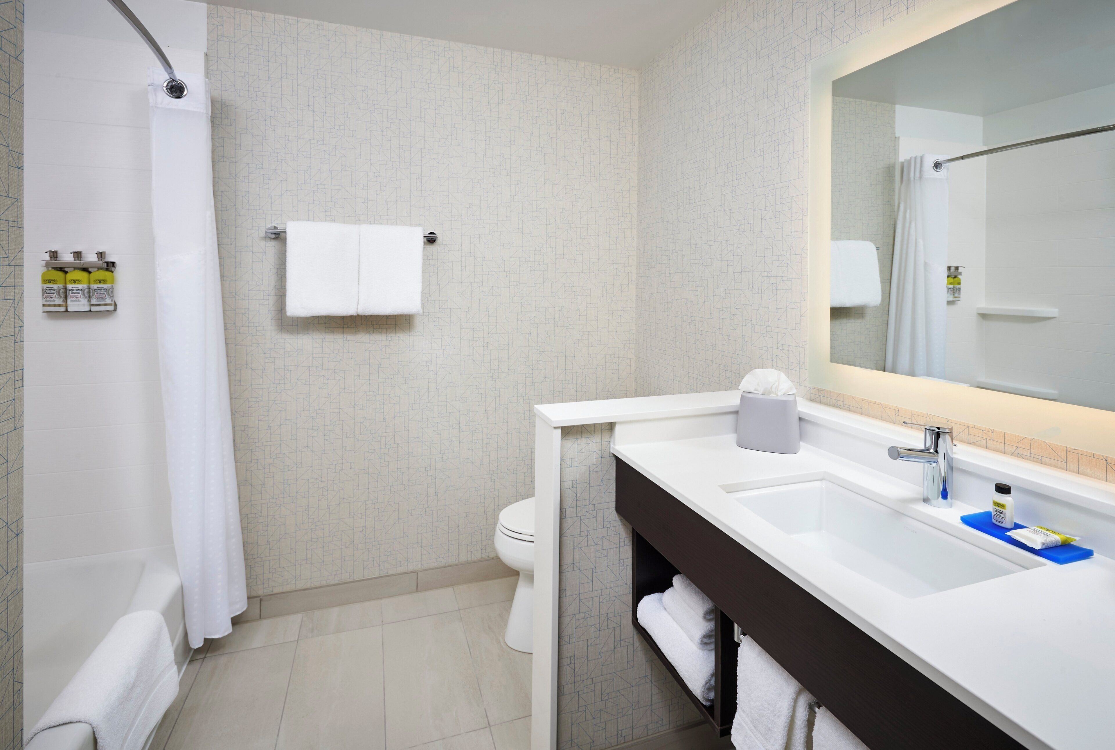 Une salle de bain moderne équipée d’une douche, de toilettes et d’un lavabo.