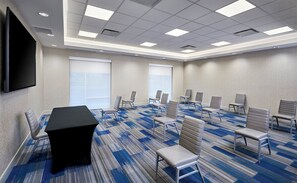 A conference room with a large table, multiple chairs, a flat-screen TV, and large windows. - Holiday Inn Express & Suites Windsor East - Lakeshore by IHG (Lakeshore)