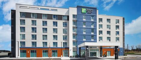A Holiday Inn Express hotel with a modern design, featuring a large parking lot and a well-maintained exterior.