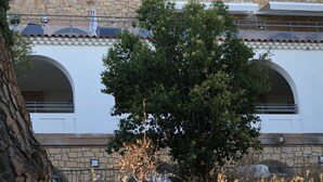 A building with a stone facade, multiple arches, and a white upper section. - A breathtaking view 5 minutes from the Chateau de Brégancon (La Londe-les-Maures)
