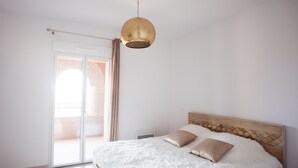 A bedroom with a bed, a ceiling light, and a sliding glass door. - A breathtaking view 5 minutes from the Chateau de Brégancon (La Londe-les-Maures)