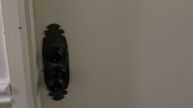 A wall-mounted device with buttons and a small metal object with a number. - 16th Floor  Beachfront Condo at the Sea Air Tower (Hollywood/Hallandale Beach)