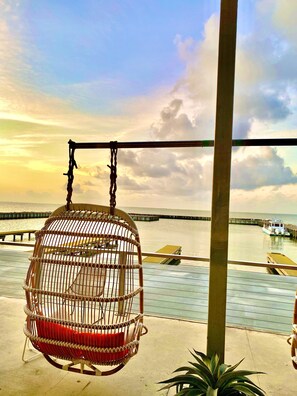 A wicker swing chair overlooking a waterfront with a boat dock. - Pet-friendly accommodations near water and restaurants. (San Leon)