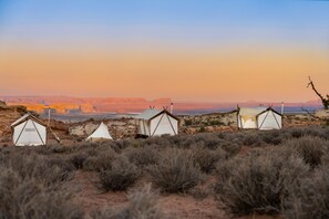 A desert landscape with multiple tents set up in a row.
