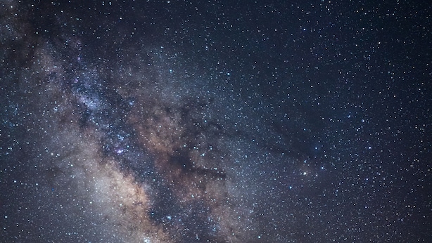 Dos tiendas de campaña amarillas con una vista despejada de la Vía Láctea en el cielo nocturno.