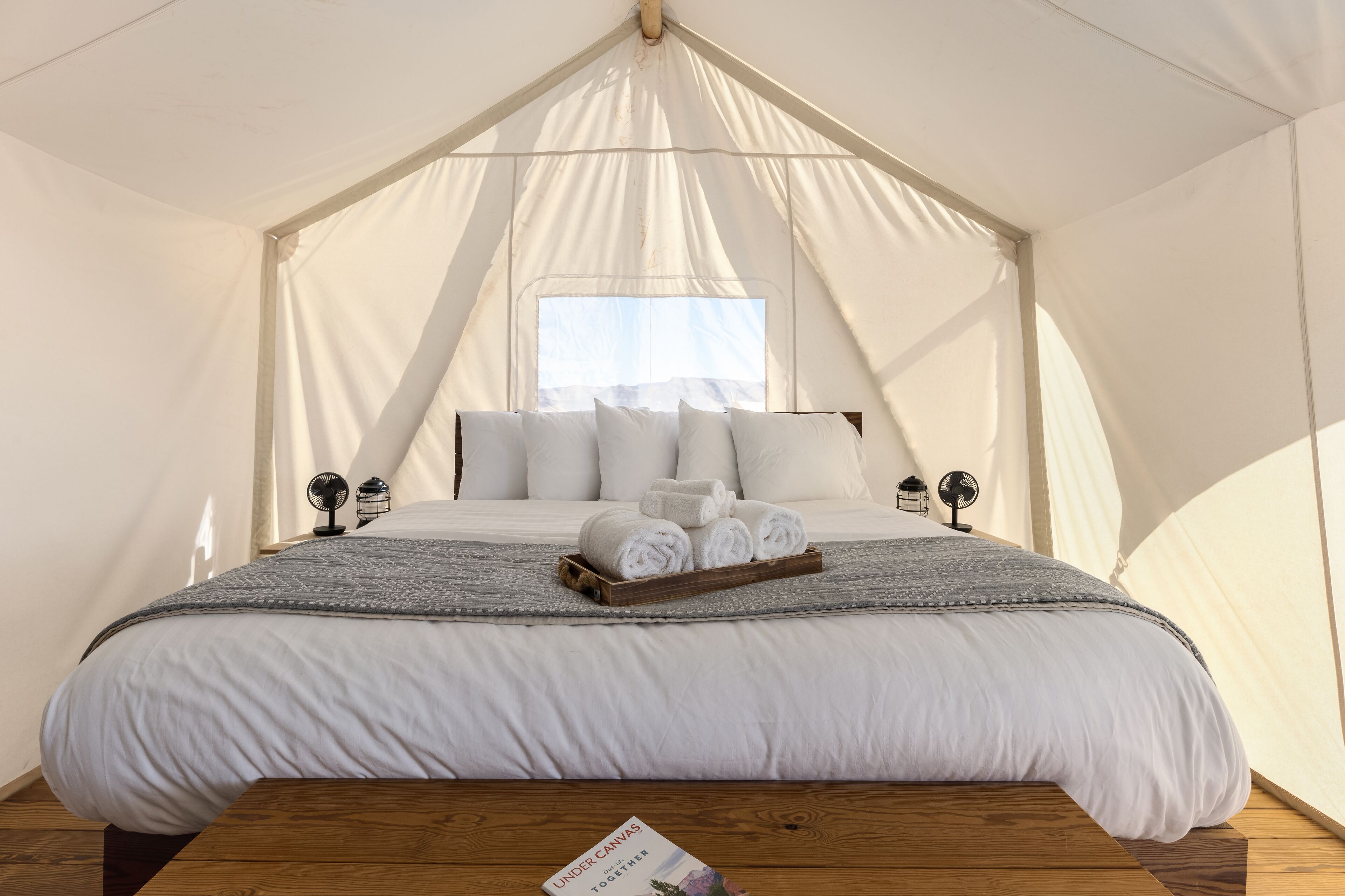 Ein Zeltraum mit Bett, Kissen und Handtüchern.